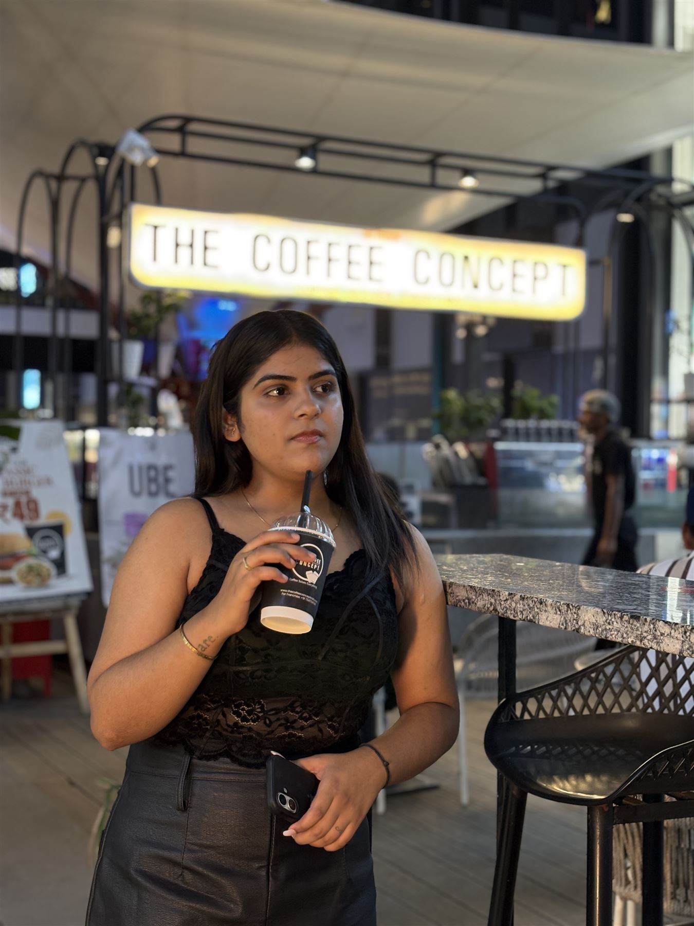 A guest with her coffee under the TCC sign